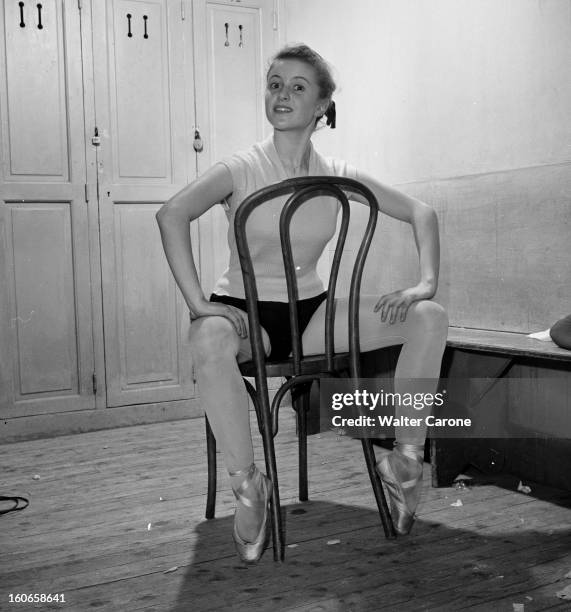 Close-up Of Violette Verdy. Dans le vestiaire du Studio WACKER, portrait de Violette VERDY assise à califourchon sur une chaise, faisant des pointes.