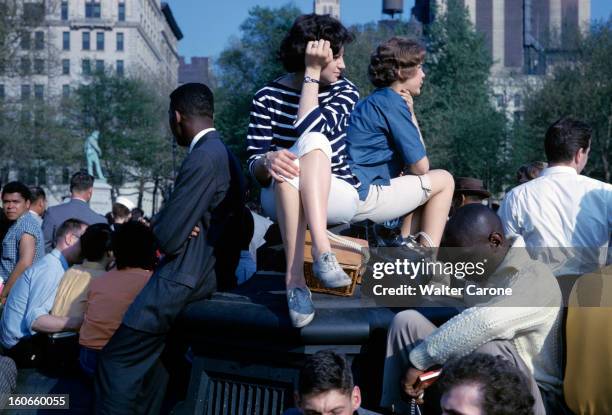 Report In Greenwich Village In New York, United States. A New York, dans Greenwich Village, un groupe de personnes est assis sur et autour d'un...