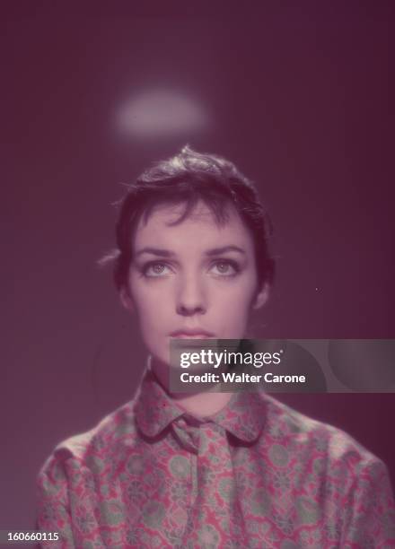 Marie Laforêt. Portrait studio de l'actrice Marie LAFORÊT, portant un chemisier à motifs fleuris rouges et verts, le regard vers le haut, un halo...