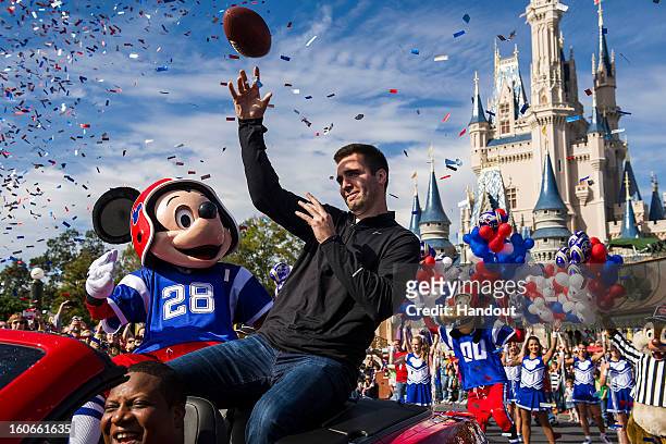 In this handout photo provided by Disney Parks, Super Bowl XLVII MVP Joe Flacco rides with Mickey Mouse in a parade through the Magic Kingdom at Walt...