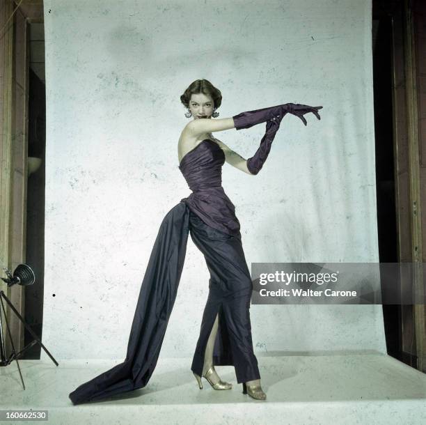 Women's Collections Spring 1951 By Fashion Designers Of Paris. A Paris, dans un studio, un mannequin présente pour SCHIAPARELLI, une robe fourreau,...