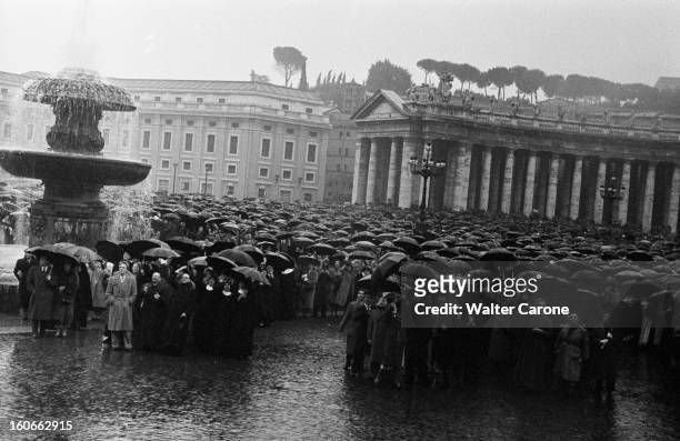 Vatican. Vatican - 24 mars 1956 - Une foule de personnes tenant des parapluies, rassemblées sous la pluie sur la Place Saint-Pierre.
