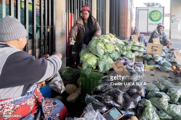 Customer pays for her goods at a kiosk at the Bara taxi rank market in Diepkloof, Soweto, on August 13, 2023.