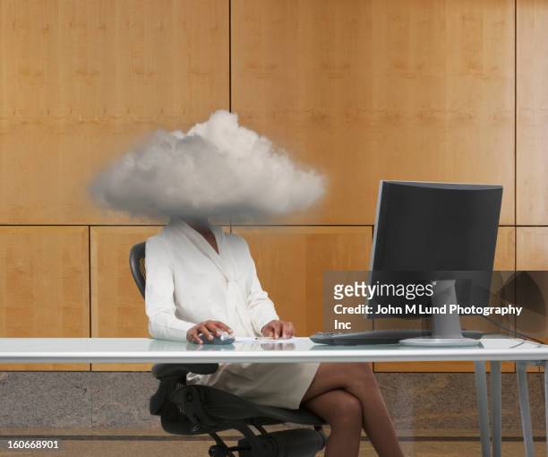 black businesswoman at desk with head in clouds - büro und wolke stock-fotos und bilder