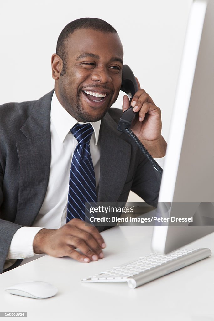 Black businessman talking on telephone at desk