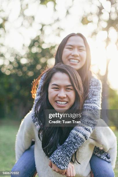 portrait of twin sisters playing at the park - asian twins 個照片及圖片檔