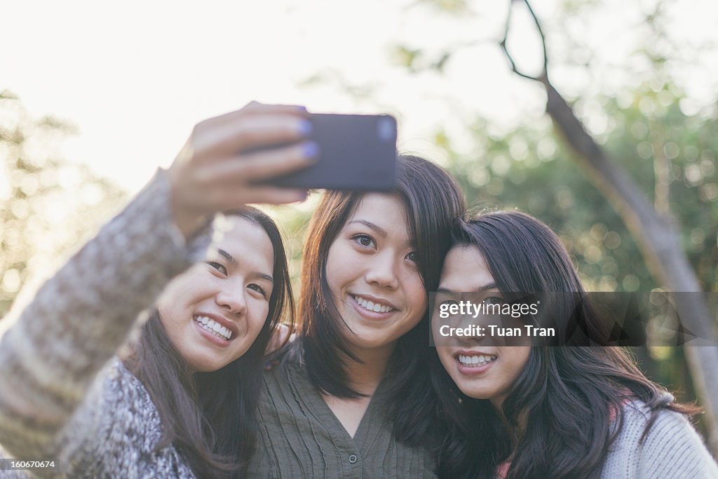 Three teenage girls taking photos of themselves