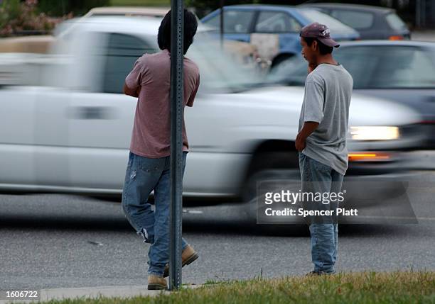Day laborers, mostly undocumented Mexican immigrants, wait for work on a street corner August 3, 2001 in Farmingville, New York. Many residents of...