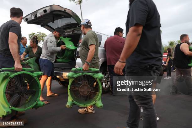 Volunteers with King's Cathedral Maui unload a donation of industrial fans on August 10, 2023 in Kahului, Hawaii. Dozens of people were killed and...