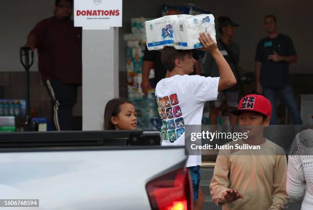 Volunteers with King's Cathedral Maui bring in donations on August 10, 2023 in Kahului, Hawaii. Dozens of people were killed and thousands displaced...