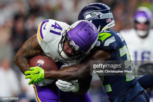 Running back Abram Smith of the Minnesota Vikings is tackled by safety Jerrick Reed II of the Seattle Seahawks during the second half of a preseason...