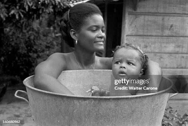 Brazil. Brésil- Période 1950-1955- Reportage sur le Brésil: à Manaus, une jeune femme souriante, cheveux crépus lissés en arrière, pose devant une...