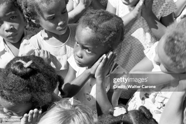 Brazil. Brésil- Période 1950-1955- Reportage sur le Brésil: plan sur des fillettes, mains jointes contre leur joue, de type créole, cheveux crépus.