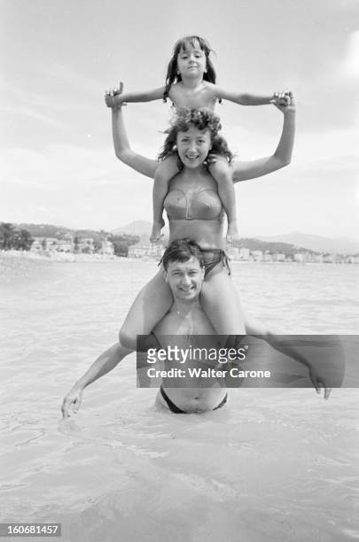 Holidays On The French Rivieira. Juillet 1951- Portrait de Colette BROSSET portant sa fille sur ses épaules, portée elle-même par son époux Robert...