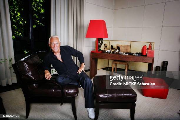 Attitude by Giorgio Armani smiling sitting in the living room of his apartment in Milan, via Borgonuovo, surrounded by his Armani Casa furniture and...