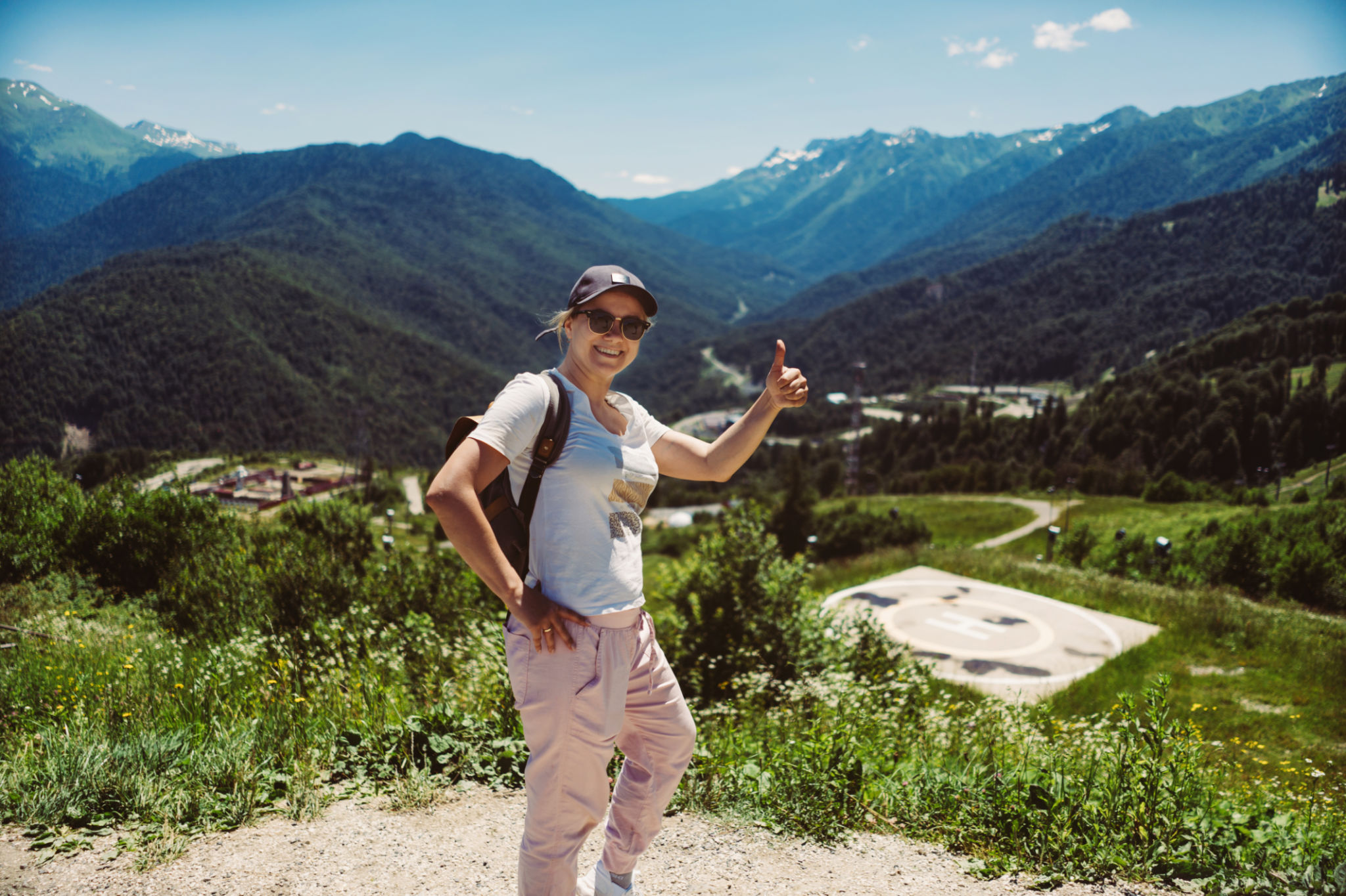 young stylish woman hiking alone with backpack enjoying beauty of mountains showing thumb up gesture young stylish woman hiking alone with backpack enjoying beauty of mountains showing thumb up gesture