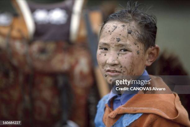 Fantastic Ride In Mongolia. Plan de face d'un jeune enfant, de la boue sur le visage, après une course à cheval lors des grandes fêtes du Naadam...