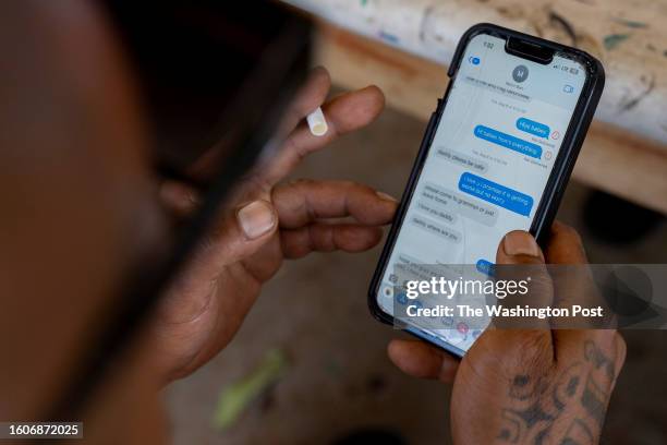 Shaun "Buge" Saribay swipes through the text messages he sent to his daughter during the wildfire at his family home in Lahaina, Hawaii on August 15,...