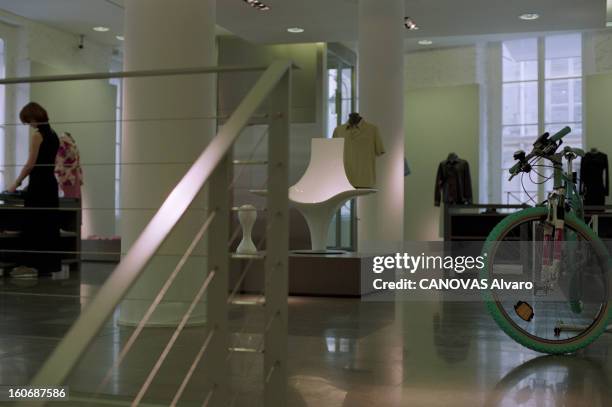 The Store 'colette' In Paris. A Paris, en mai 1997, dans le magasin 'COLETTE', une femme arrangeant des articles sur un présentoir, près d'un vélo...