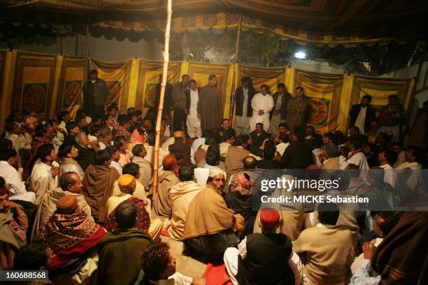 Asif Ali Zardari sitting under a tent in the courtyard of the headquarters of the PPP in Larkana, surrounded by many very faithful.