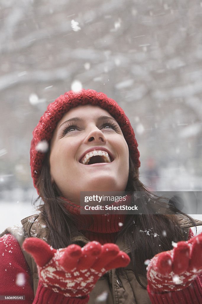 Young woman enjoying snow falling