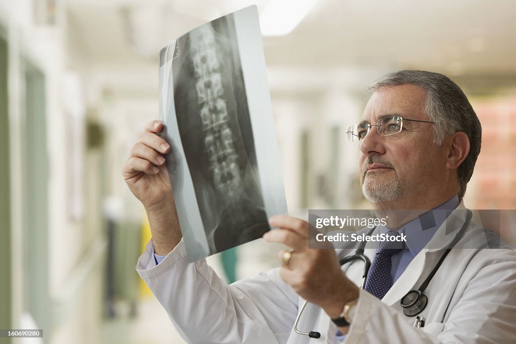 Älterer Arzt Blick in die Röntgenapparate