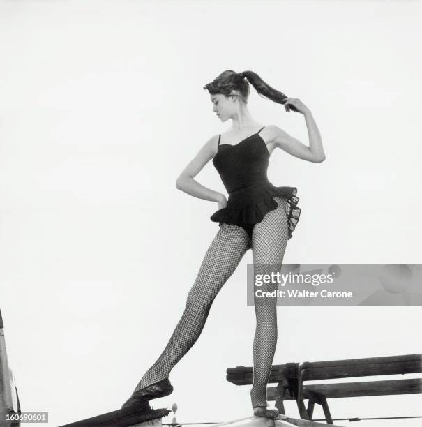 Brigitte Bardot Rehearse Dancing On The Roofs Of Paris. Attitude de Brigitte BARDOT de profil, en tenue de danseuse , se tenant la queue de cheval,...