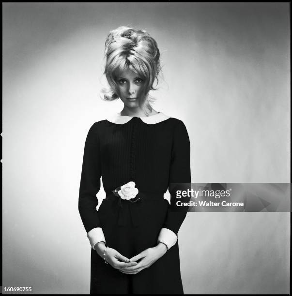 Photo Studio Of Catherine Deneuve. Photo studio : plan de face de Catherine DENEUVE posant dans une petite robe noire à col blanc, la jeune...