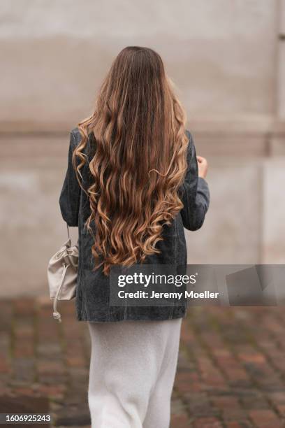 Zoë Pastelle is seen wearing a cream white wool knit zip collar long dress, black washed leather blazer jacket, latte white and cream leather pouch...