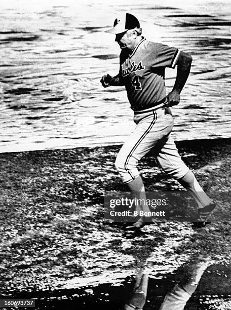 Manager Earl Weaver of the Baltimore Orioles jogs through the water on the field as rain forces the postponment of Game 1 of the 1979 World Series...