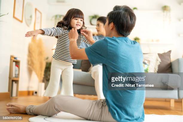 positive family relationships are built on quality time and help children feel secure and loved. shot of an adorable little girl and her father getting and adjusting a sweatshirt collar in matching. - 広がり ストックフォトと画像