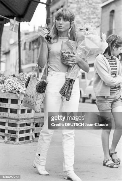 Rendezvous With Marie-france Pisier. Paris - 23 août 1967 - Sur un marché, portrait de l'actrice Marie-France PISIER tenant un bouquet de fleurs et...