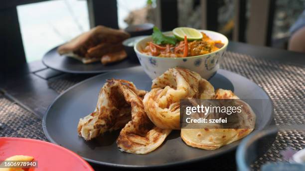 malaysian cuisine roti canai, indian food with chicken curry sauce - roti canai stock pictures, royalty-free photos & images