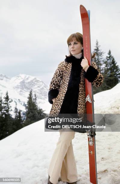 Rendezvous With An Avalanche Of Stars In Avoriaz. Nathalie WOOD, vêtue d'un manteau imitation léopard, pose, jambes croisées, une paire de skis...