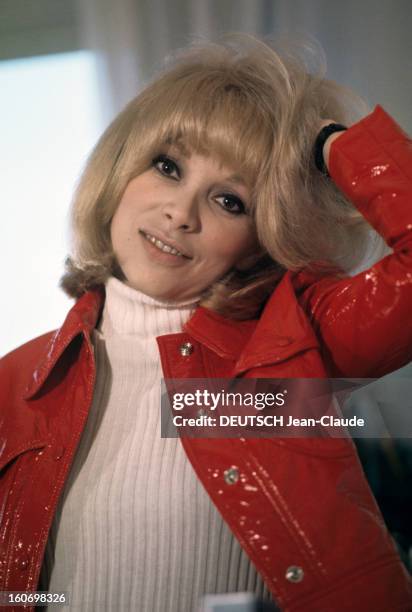 Rendezvous With Mireille Darc. En avril 1970, l'actrice Mireille DARC pose dans un appartement, en veste de vinyle rouge, et pull blanc, se passant...