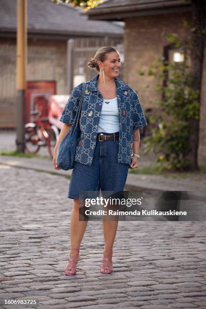 Janka Polliani wears blue shorts, light blue tank top, blue shirt outside Ganni during the Copenhagen Fashion Week Spring/Summer 2024 on August 10,...