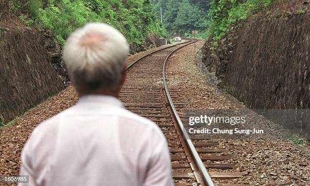 Kim Sa-Bok, a survivor of an alleged civilian massacre by US troops during the Korean war, looks at railroad tracks August 4, 2001 at the scene of...