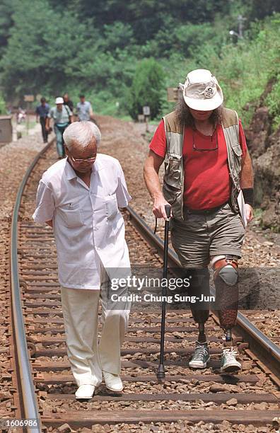 Kim Sa-Bok, left, a survivor of an alleged civilian massacre by US troops during the Korean war, walks with Brian Wilson, the head of the Korea Truth...