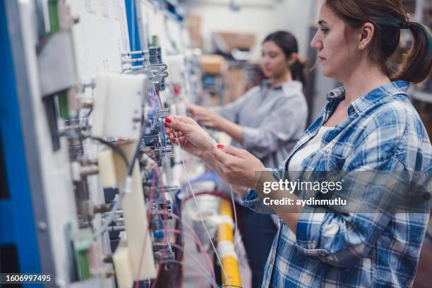 young women working on the production line in factory - garment factory stock pictures, royalty-free photos & images