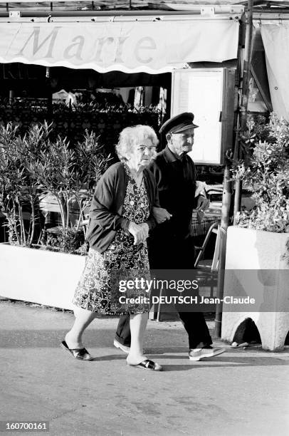 Naiads Are Back. Saint-Tropez, 30 juin 1971- Reportage sur les naïades de la plage: un vieux couple, lui portant une casquette de marin, elle en robe...