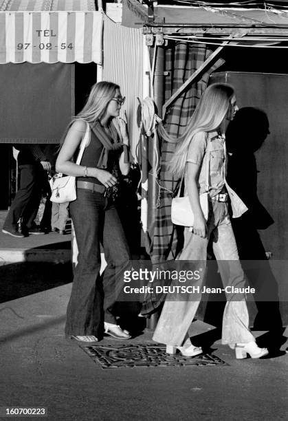Naiads Are Back. Saint-Tropez, 30 juin 1971- Reportage sur les naïades de la plage: deux jeunes femmes blondes se promènent, vêtues de pantalon à...