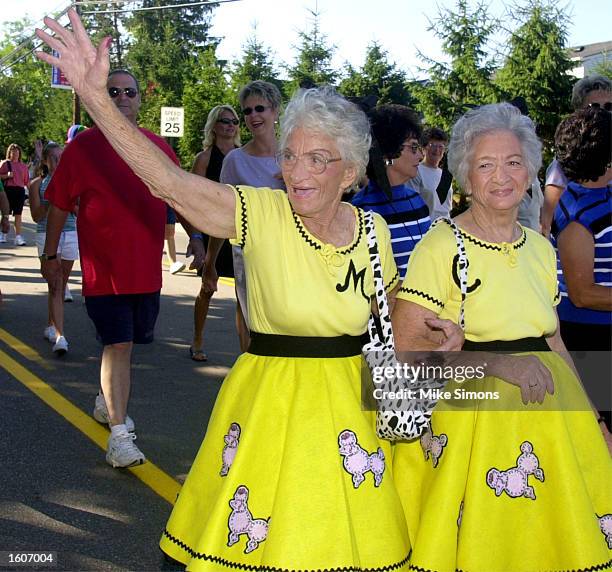 Twins Mary Wigal and Carrie Gallwitz of Columbus, OH wave as they take part in the parade at the Twinsburg Twins Days Festival August 4, 2001 in...