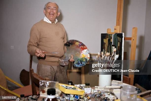 Report On The Island Of Ibiza. Ibiza - mars 1972 - Portrait du peintre faussaire Elmyr DE HORI, dans son atelier, tenant une palette, devant un...