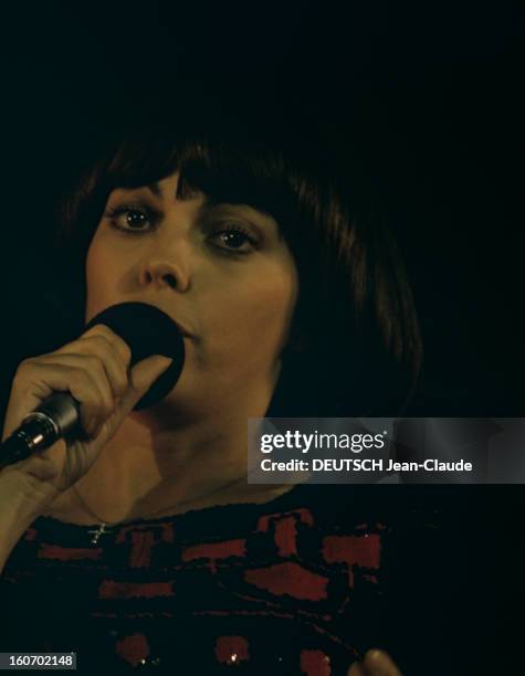 Close-up Of Mireille Mathieu In Gdr . RDA-1972 - Portrait de Mireille MATHIEU, chantant micro en main, portant une croix en pendentif sur une chaîne...