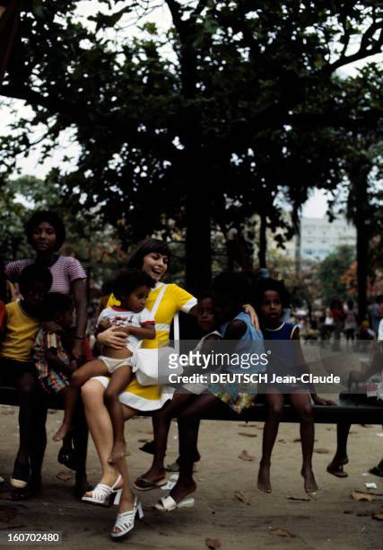 Rendezvous With Mireille Mathieu In Brazil. Au Brésil, en octobre 1972, dans un parc, assise sur une poutre, Mireille MATHIEU souriante, vêtue d'une...