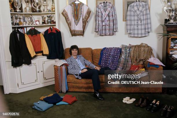 Men's Fashion. France- Paris - 1973- François CEVERT, champion de l'automobile, pose demi-allongé dans un canapé, vêtu d'une veste à carreaux noirs...