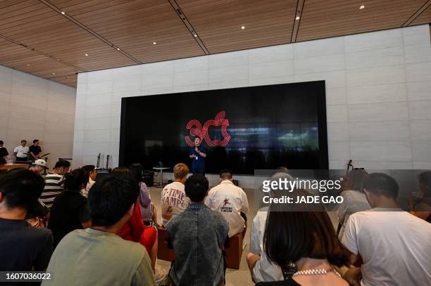 People attend an event celebrating Apple's 30th anniversary in China at an Apple retail store in Beijing on August 18, 2023.