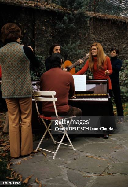 Close-up Of Dalida. Dalida en compagnie de Luigi s'entraîne avec son groupe de musiciens dans le jardin de sa maison: un pianiste, un guitariste...