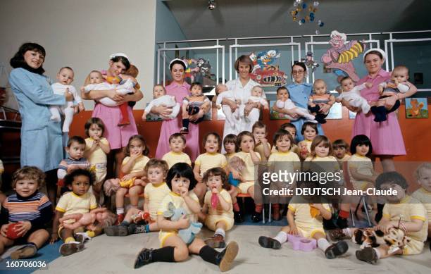 The Old France In Year 2000. Dans une crèche, plusieurs nurses en tenue professsionnelle, blouse rose, blanche ouu bleue ciel et couvre-chef en coton...
