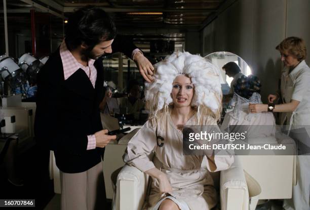 The Big Names Of Hairdressing. Paris - 1976 - Faubourg Saint-Honoré, devant une coiffeuse s'occupant d'une cliente assise de dos, dans le salon des...